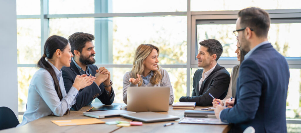 A group of people in a meeting around a table.